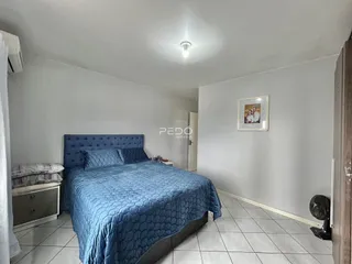 Foto de um quarto com cama azul e piso de cerâmica em um imóvel.