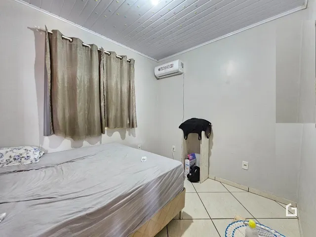 Quarto com cama e janela decorada em imóvel no Brasil.