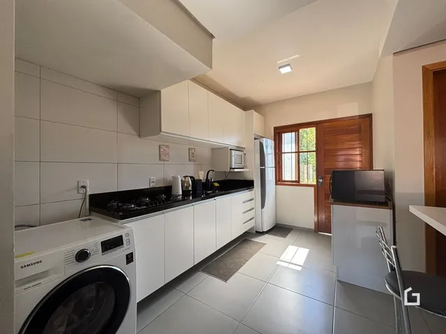 Foto de uma cozinha moderna com armários brancos e piso de cerâmica.
