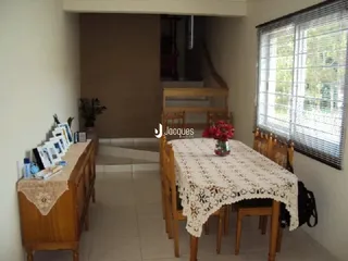 Sala de estar com móveis de madeira e janela com persianas.