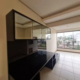 Foto de um ambiente interno com armários escuros e uma grande janela.