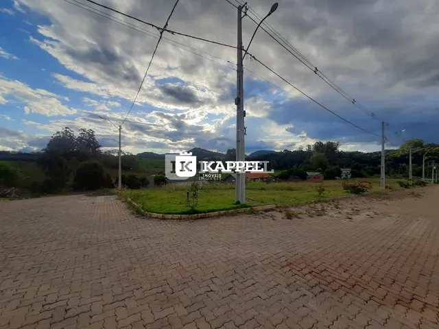 Vista panorâmica de uma área externa com gramado e colinas ao fundo.