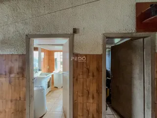 Vista de um corredor interno com duas portas abertas em uma residência.