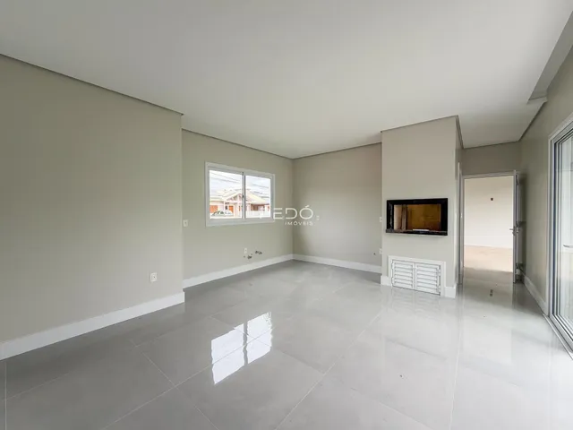 Vista interna de um ambiente com paredes claras e piso de grande formato.