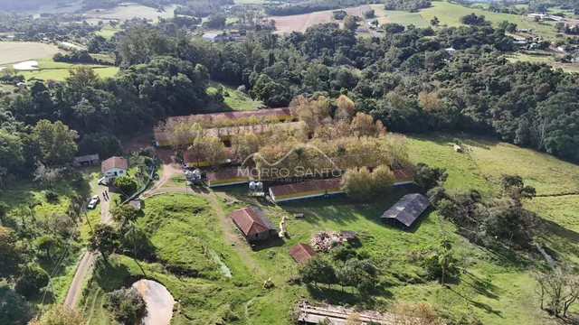 Vista aérea de uma propriedade rural com vegetação densa e construções dispersas em Lajeado.