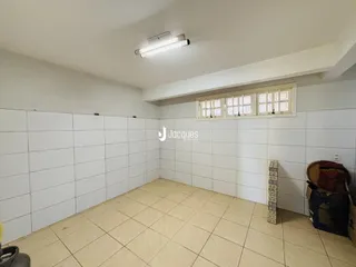 Uma sala de estar com piso de cerâmica clara e paredes brancas.