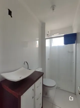 Foto de um banheiro interno com vaso sanitário e pia brancos.