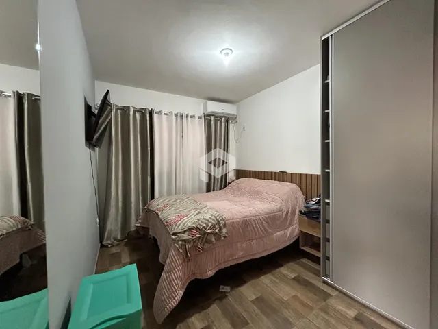 Quarto com cama e cortinas em ambiente interno.