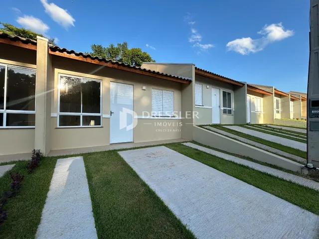Fachada de casas em Lajeado, Brasil, com jardim e calçada.