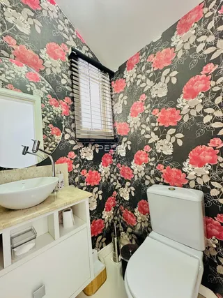 Foto de um banheiro com revestimento de parede floral.