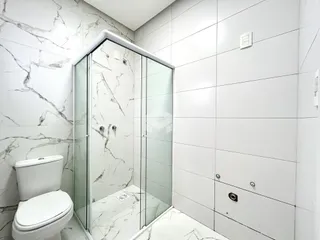 Banheiro com revestimento de mármore nas paredes e piso.