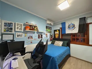 Quarto com cama e área de trabalho em um imóvel no Brasil.