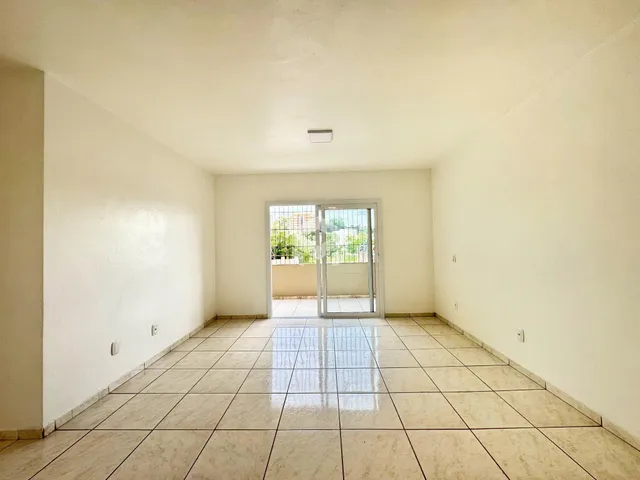 Interior de uma sala com piso de cerâmica e porta de vidro.