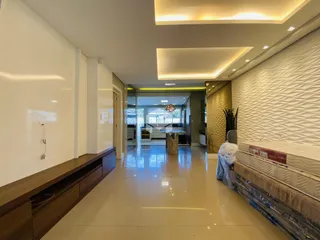 Sala de estar moderna com teto alto e iluminação embutida.