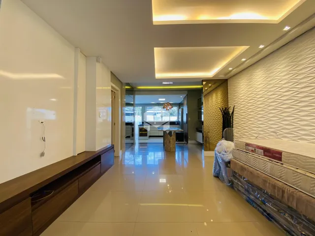 Sala de estar moderna com teto alto e iluminação embutida.