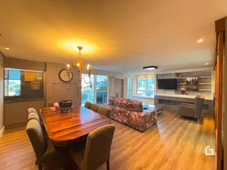 Sala de estar e jantar com piso de madeira e móveis.