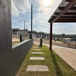 Vista externa mostrando um caminho pavimentado e área gramada.