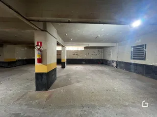 Interior de um corredor com paredes de concreto aparente.
