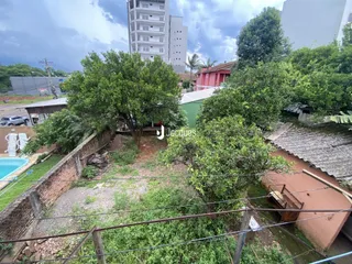 Vista externa de uma propriedade com vegetação densa e cercas no Brasil.