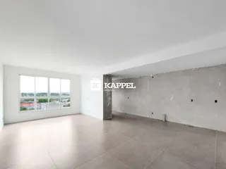 Uma sala ampla e vazia com grande janela mostrando a paisagem externa.