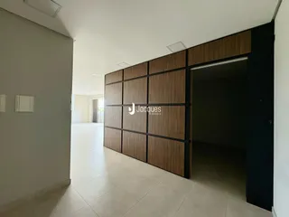 Hall de entrada com piso claro e parede de madeira.