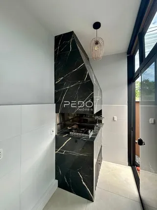 Vista da cozinha com revestimento de mármore escuro.