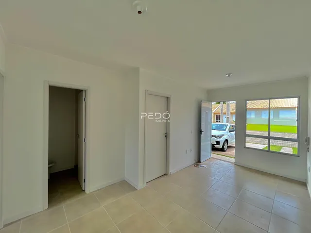Interior de um corredor com piso de cerâmica claro.