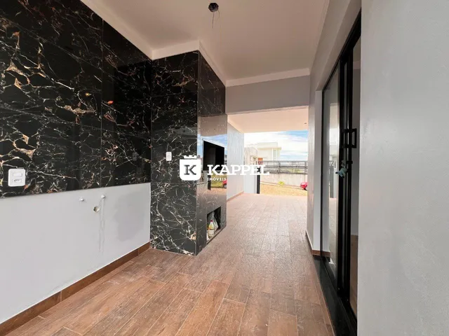Hall de entrada com revestimento de mármore preto e piso de madeira.