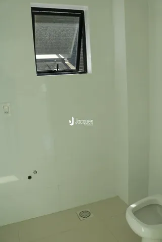 Foto de uma parede interna com um vaso sanitário branco.