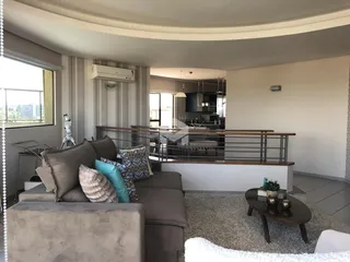 Sala de estar com sofá e vista para a área da cozinha.
