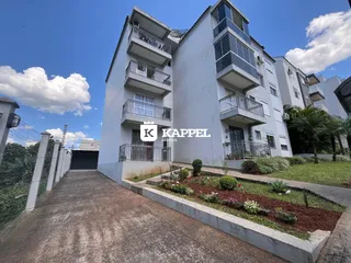 Fachada de um prédio residencial em Lajeado, Brasil, com jardim na frente.