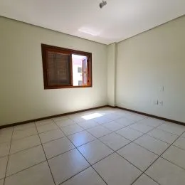 Foto de um cômodo interno com piso de cerâmica claro e janela.