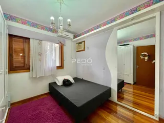 Quarto com piso de madeira e decoração de parede em imóvel no Brasil.