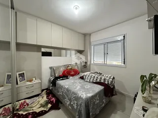 Foto de um quarto com cama e armários brancos em um imóvel.