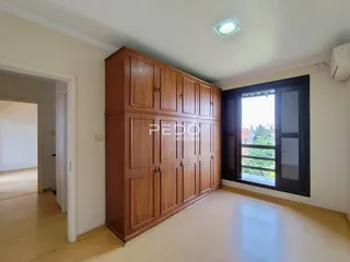 Interior de uma sala com armário de madeira e porta de vidro.