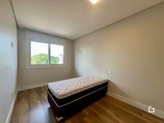 Quarto com piso de madeira e janela.