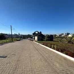 Vista da rua em Lajeado, Brasil, mostrando uma via pavimentada e vegetação ao lado.