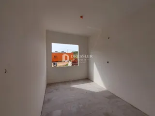 Interior de um ambiente com paredes brancas e piso claro.