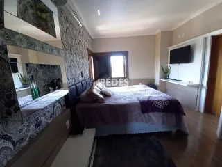 Quarto com cama e decoração de parede em um imóvel.