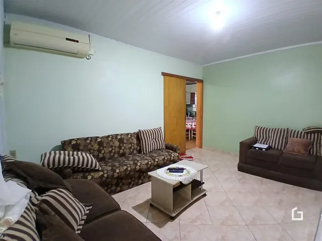 Sala de estar com sofás marrons e paredes verde claro.