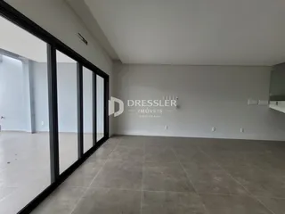 Interior de um espaço amplo com piso de cerâmica e paredes brancas.