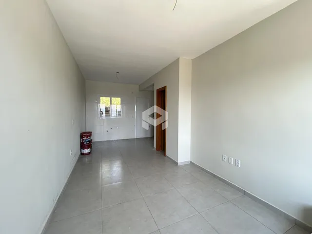 Corredor interno com paredes brancas e piso de cerâmica.