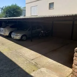 Foto de uma área coberta de estacionamento adjacente à residência.