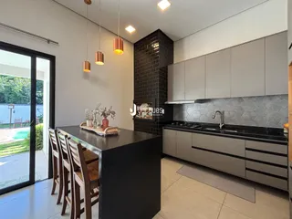 Cozinha moderna com ilha e portas de vidro de acesso ao jardim.