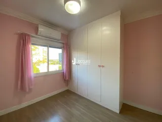 Um quarto com paredes rosa e piso de madeira clara.