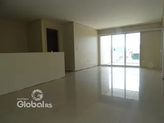 Foto de uma sala ampla com piso claro e porta de vidro.