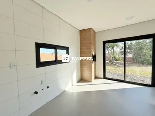 Sala de estar com paredes brancas e porta de vidro que dá acesso ao quintal.