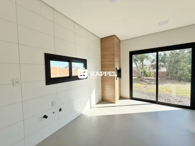 Sala de estar com paredes brancas e porta de vidro que dá acesso ao quintal.