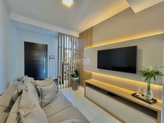 Sala de estar moderna com sofá e televisão em um apartamento.