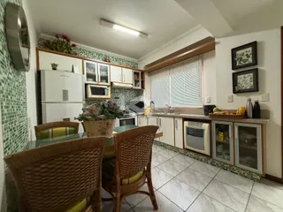Uma cozinha com armários e mesa de jantar em um ambiente interno.